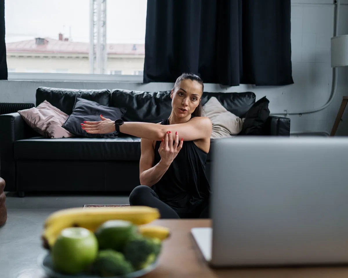 Online coaching client following a workout on her laptop at home